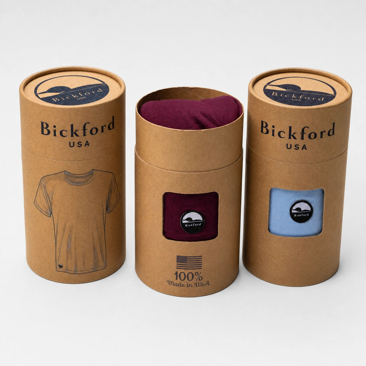 Bickford USA product packaging featuring three kraft paper tee tubes, including burgundy and light blue tees visible through the front windows with Bickford logo patches.