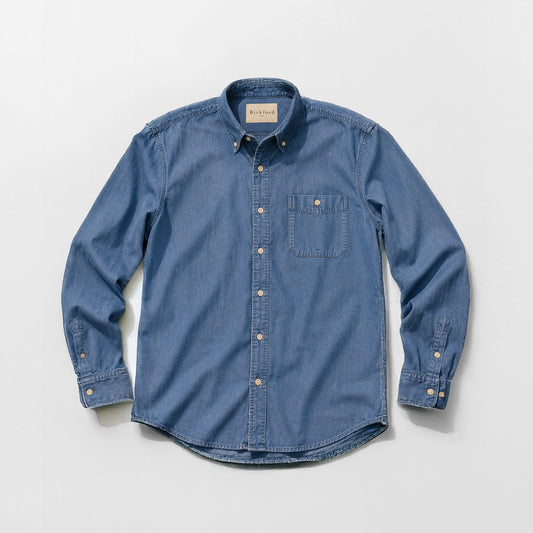 Bickford USA Denim Field Shirt in medium wash chambray denim, flat lay front view, featuring a button-down collar, single chest pocket with button flap, cream buttons down the placket, and button cuffs, against a light gray background.