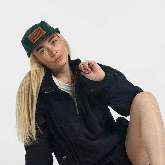 Woman wearing Bickford USA Field Patch 5-Panel Wool Cap in green with black quarter-zip