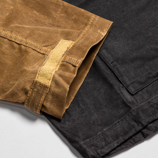 Close-up of the Bickford USA Anorak Sailcloth Jacket cuff, showing the adjustable hook-and-loop tab and waxed cotton construction in tan and black.