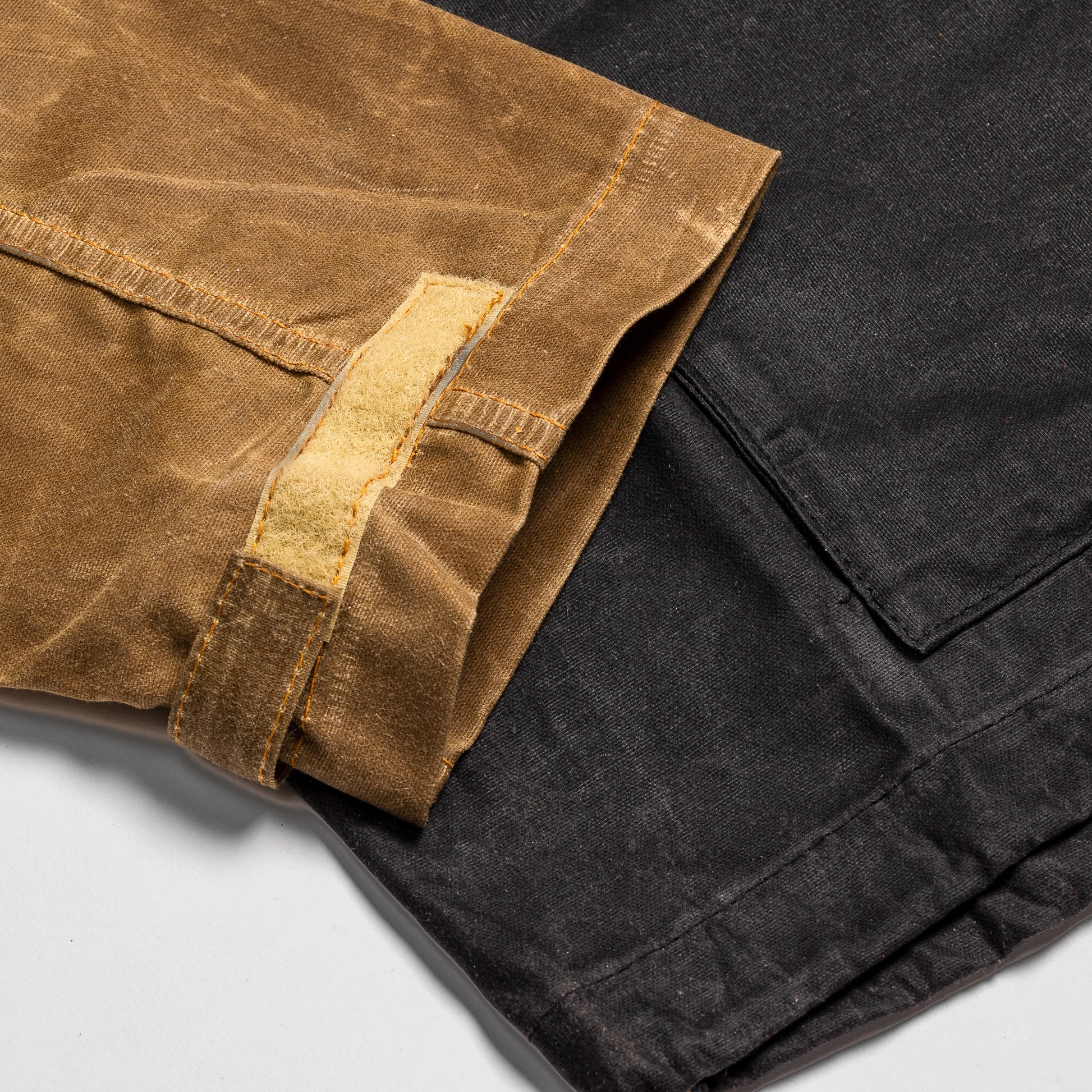 Close-up of the Bickford USA Anorak Sailcloth Jacket cuff, showing the adjustable hook-and-loop tab and waxed cotton construction in tan and black.