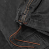 Close-up of the Bickford USA Anorak Sailcloth Jacket hem drawcord with leather pull and toggle on black waxed cotton.