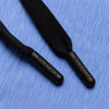 Close-up of Bickford engraved black drawstring tips on Blue Bird athletic jogger fabric