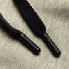 Close-up of Bickford engraved black drawstring tips on Cloud Gray athletic jogger fabric