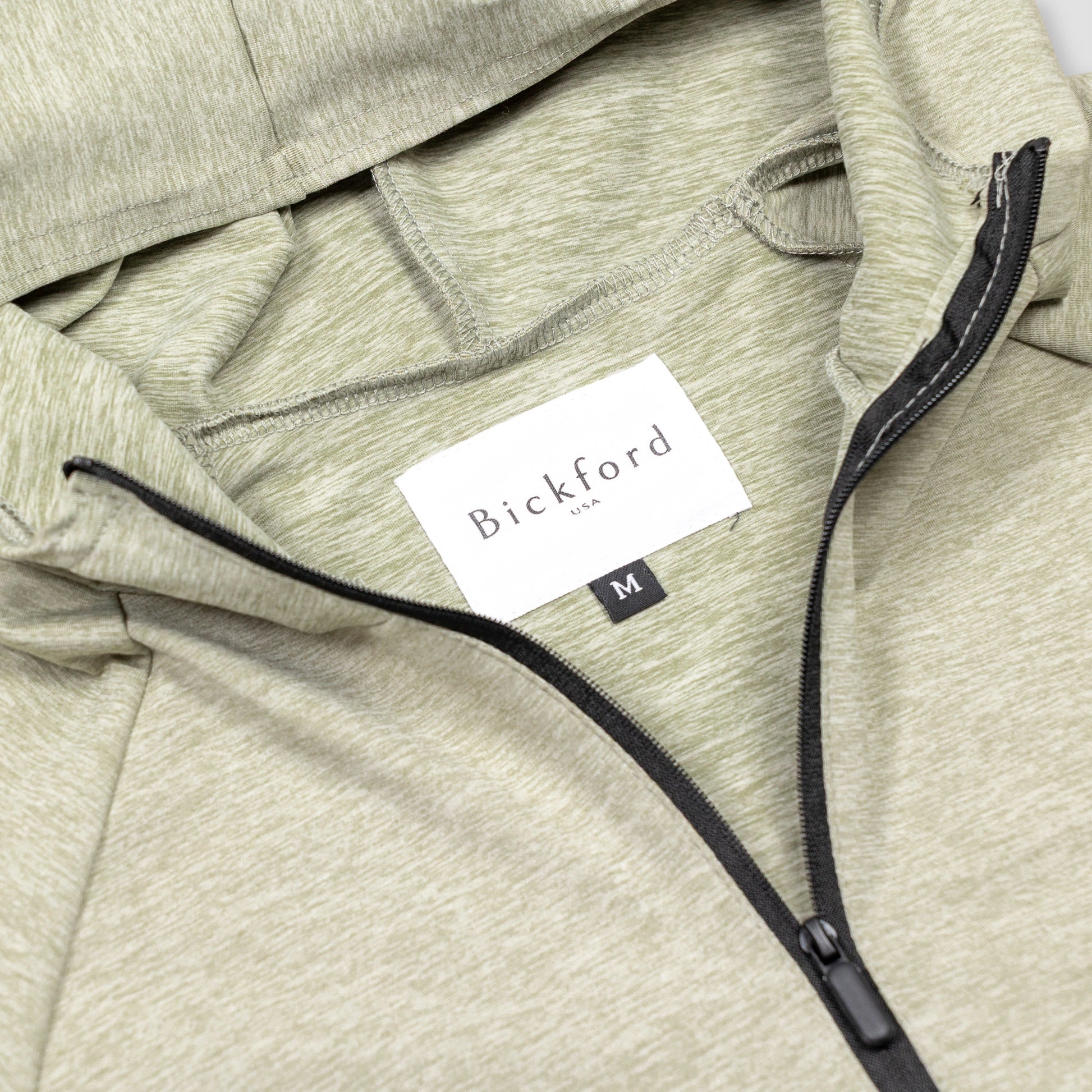 Close-up of Bickford USA woven label and black quarter zipper on Cloud Gray hoodie