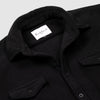 Close-up detail of the open collar and upper chest of the Bickford USA black button-down fleece overshirt, showing the spread collar, Bickford USA size M label inside the neck, matte black buttons, and chest pocket flap.
