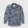 Bickford USA button-down fleece overshirt in the Boulder colorway — a gray base with an allover black geometric and tribal print — flat lay front view, featuring a spread collar, dual chest pockets with button flaps, a full button placket with dark buttons, and a curved hem, against a light gray background.