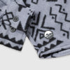 Close-up detail of the cuff and lower hem of the Bickford USA Boulder colorway button-down fleece overshirt, showing the two-button barrel cuff, dark buttons, and a circular woven Bickford logo patch on the lower left hem.