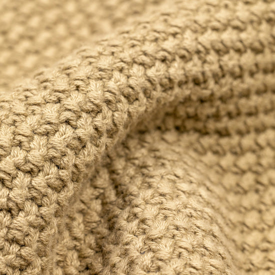 Close-up detail of the cream Fisherman Crewneck showing the folded hem and cuff area, highlighting the contrast between the seed stitch body fabric and the ribbed knit trim.