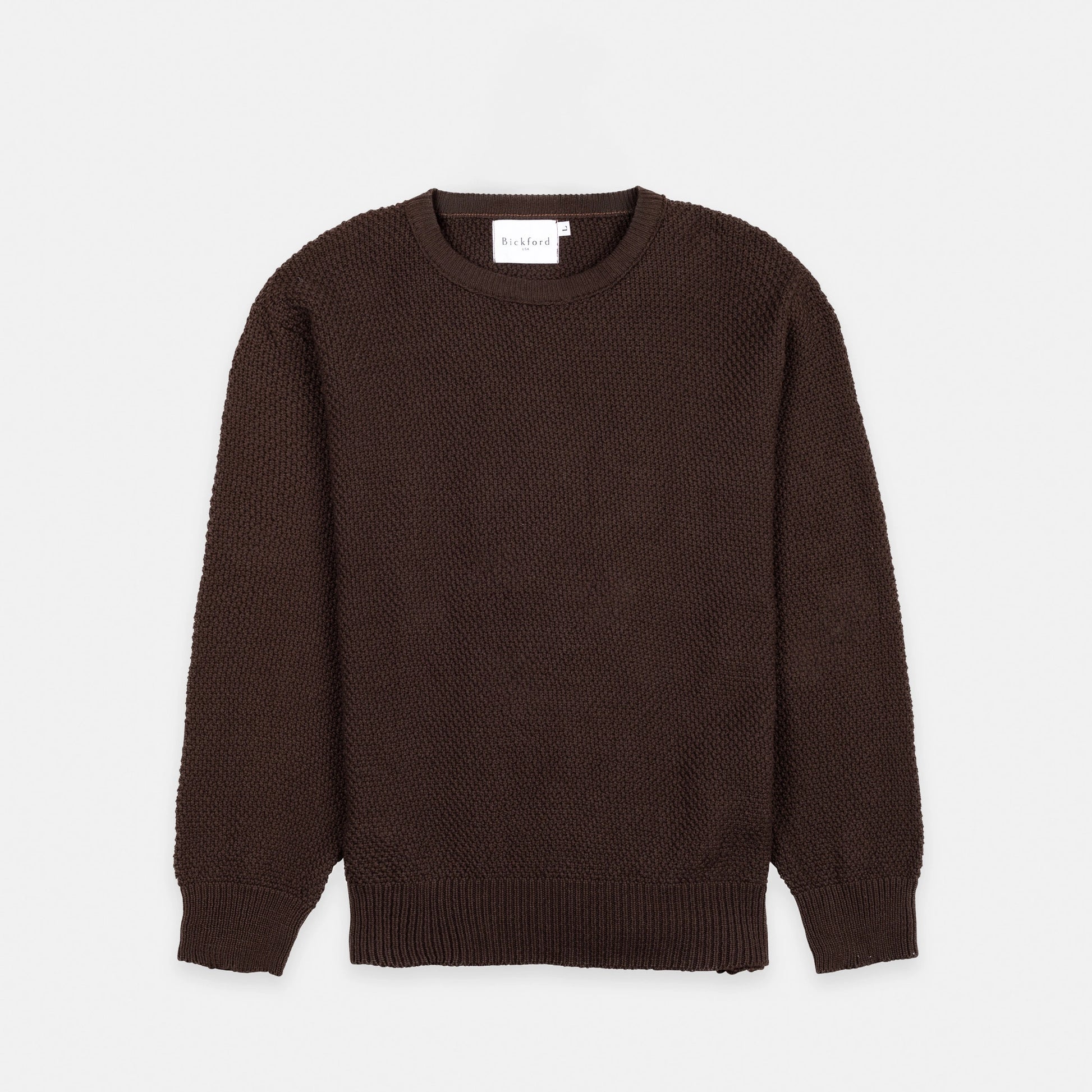 Bickford USA Fisherman sweater in dark brown, laid flat on a light gray background, showing the full front with seed stitch knit texture and ribbed crew neck, cuffs, and hem.