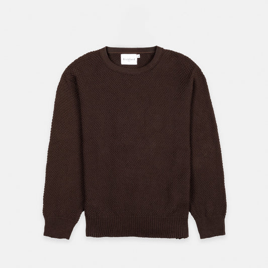 Bickford USA Fisherman sweater in dark brown, laid flat on a light gray background, showing the full front with seed stitch knit texture and ribbed crew neck, cuffs, and hem.