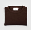 Bickford USA Fisherman sweater in dark brown, neatly folded and photographed from above, with the Bickford USA label visible at the center of the neckline.