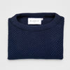 Bickford USA Fisherman sweater in navy, neatly folded and photographed from above, with the Bickford USA label visible at the center of the neckline.