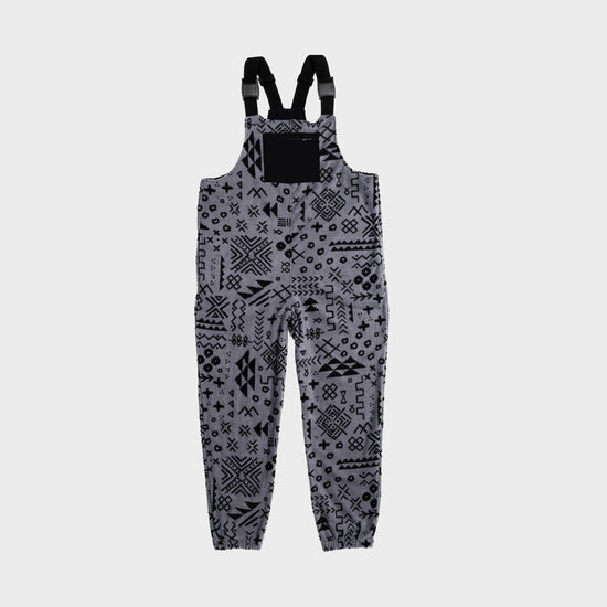Bickford USA fleece overall bib in the Boulder colorway — a gray base with an allover black geometric and tribal print — front view with black chest pocket and Fidlock buckles, against a light gray background.