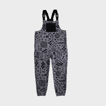 Bickford USA fleece overall bib in the Boulder colorway — a gray base with an allover black geometric and tribal print — front view with black chest pocket and Fidlock buckles, against a light gray background.
