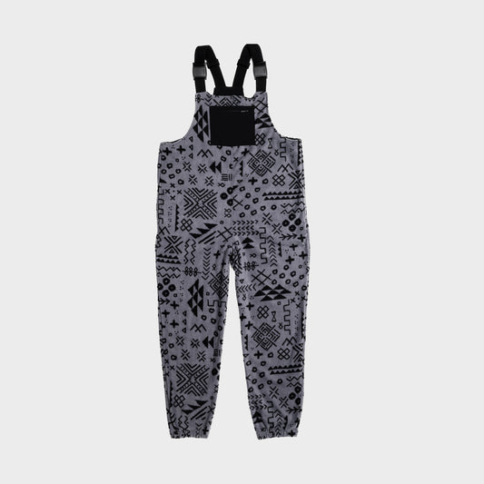 Bickford USA fleece overall bib in the Boulder colorway — a gray base with an allover black geometric and tribal print — front view with black chest pocket and Fidlock buckles, against a light gray background.
