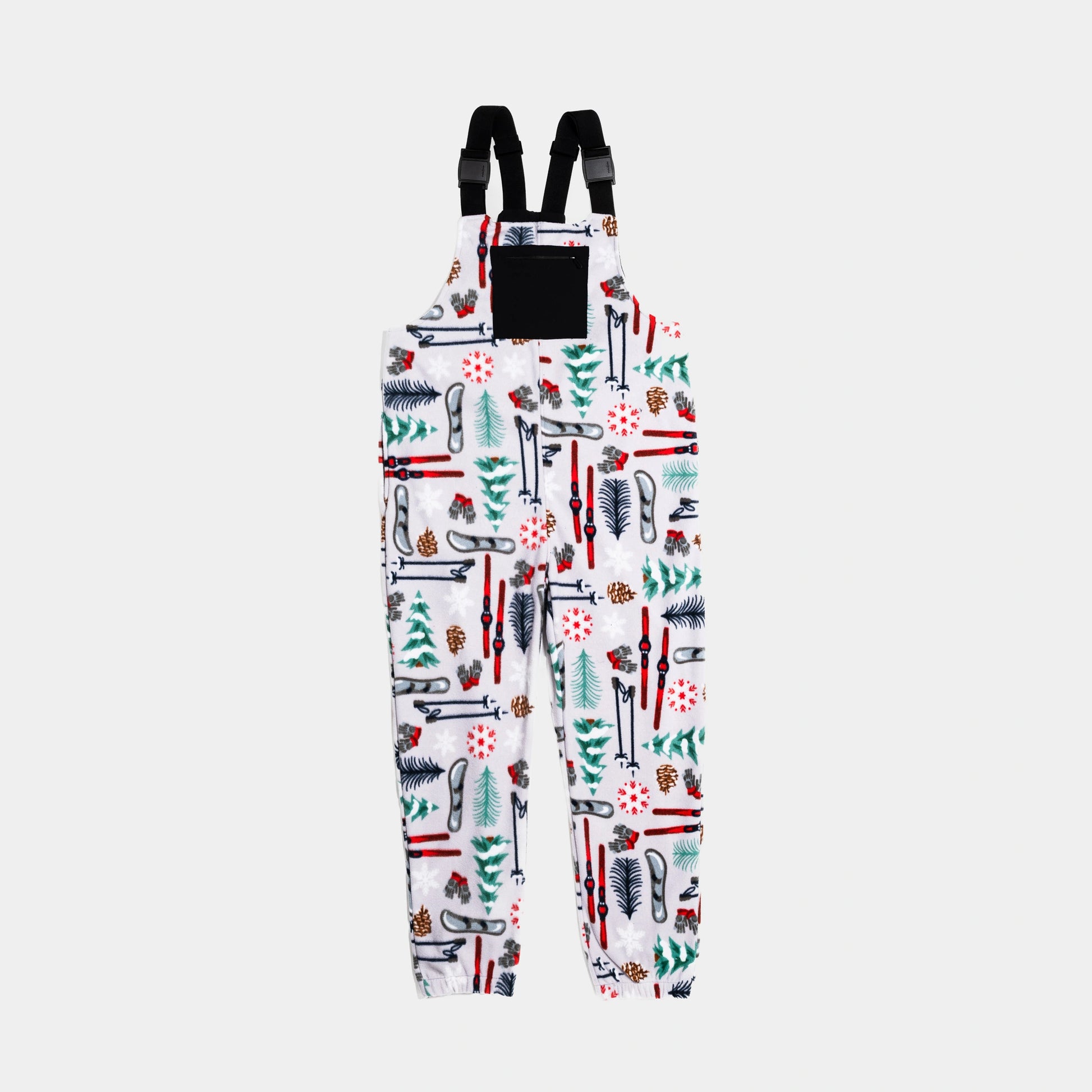 Bickford USA fleece overall bib in the Sugarbush colorway — a white base with an allover winter ski resort print featuring red skis, ski poles, snowboards, evergreen trees, pine cones, ski gloves, and red snowflakes — front view with black chest pocket and Fidlock buckles, against a light gray background.