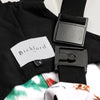 Close-up detail of a Bickford USA label with size S tag and Fidlock magnetic buckle hardware on the Sugarbush colorway overall bib, with black interior lining and the colorful ski-themed print fleece visible at the edges.