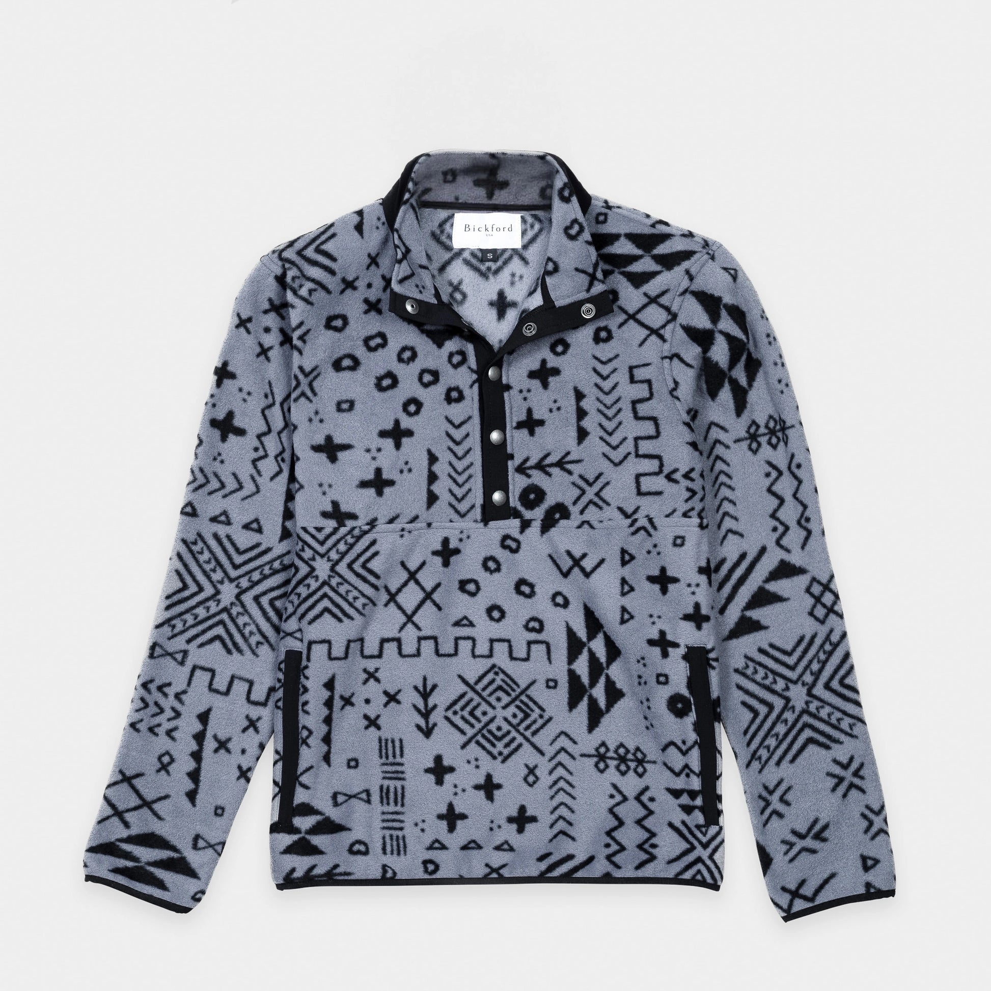 Bickford USA quarter-snap fleece pullover in the Boulder colorway — a gray base with an allover black geometric and tribal print — flat lay front view, featuring a black grosgrain placket with silver snap buttons and matching trim, against a light gray background.