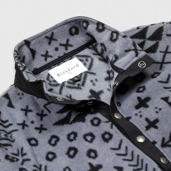 Close-up detail of the open collar and snap placket on the Bickford USA Boulder colorway quarter-snap pullover, showing the black grosgrain trim, silver snap buttons, and Bickford USA size S label inside the collar.
