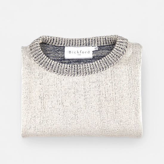Bickford USA The 1926 Sweater in natural and grey, neatly folded and photographed from above, with the Bickford USA label visible at the center of the contrasting grey ribbed neckline.