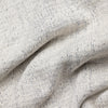 Extreme macro close-up of The 1926 Sweater fabric in natural and grey, showing the fine marled knit texture with natural cream yarn flecked throughout with dark grey.