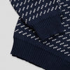 Close-up detail of The 1926 Sweater in navy and natural showing the folded hem and cuff area, highlighting the contrast between the diagonal birdseye patterned body and the solid navy ribbed trim.