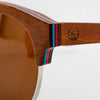 Close-up of the Bickford USA Timberline Half-Frame Sunglasses temple in walnut, showing the layered red and teal skate-deck wood and engraved loon logo.