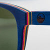 Close-up of the Bickford USA Timberline Full-Frame Sunglasses temple in deep blue, showing the layered skate-deck wood and engraved loon logo.