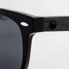 Close-up of the Bickford USA Timberline Full-Frame Sunglasses temple in midnight black, showing the wood temple inlay and engraved loon logo.