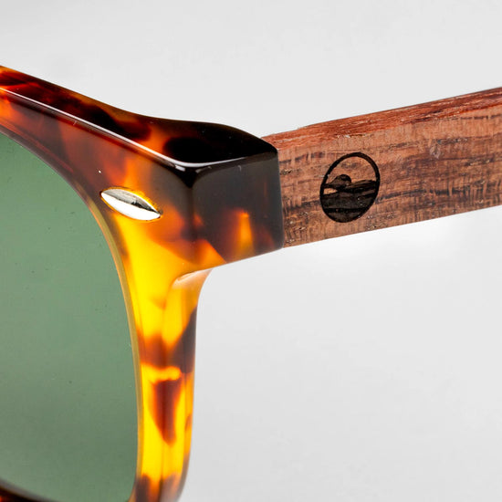 Close-up of the Bickford USA Timberline Full-Frame Sunglasses temple in tortoise, showing the wood temple inlay and engraved loon logo.