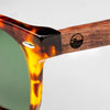 Close-up of the Bickford USA Timberline Full-Frame Sunglasses temple in tortoise, showing the wood temple inlay and engraved loon logo.