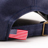 Close-up of American flag tag and antique brass buckle strap on Bickford Navy chino cap