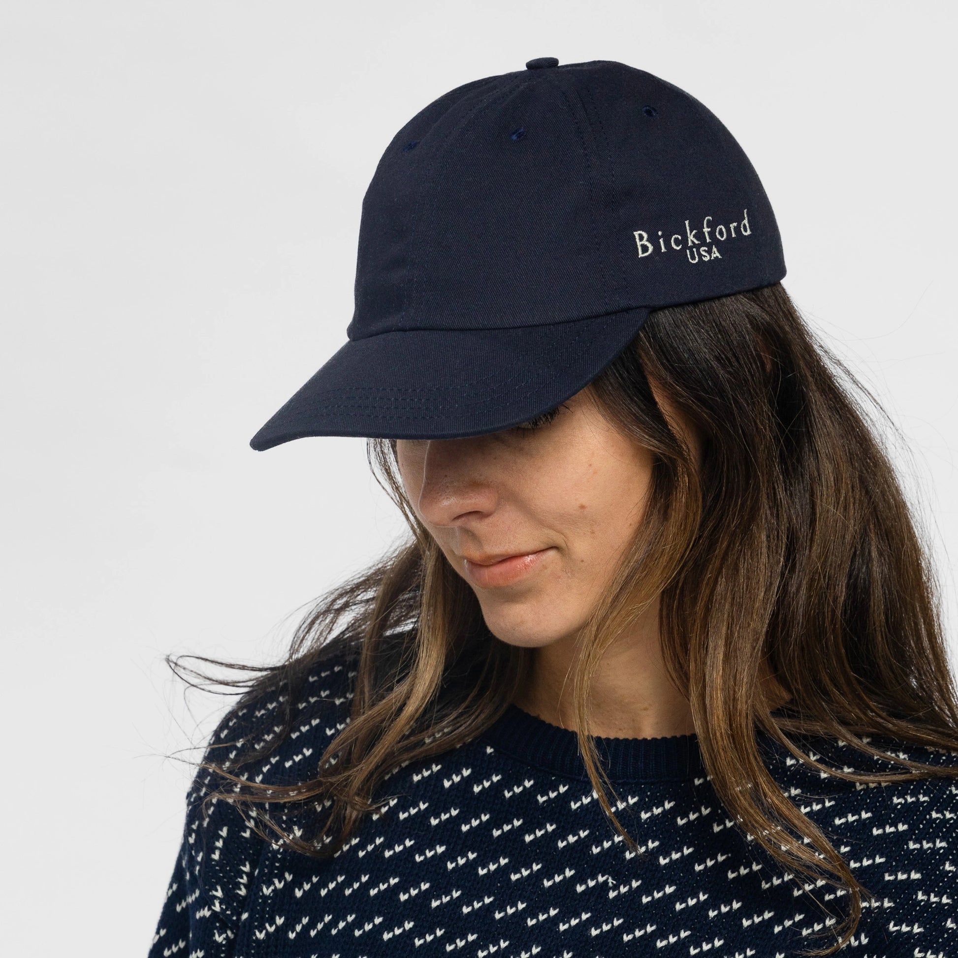 Woman wearing Bickford USA Unstructured Chino Cap in Navy with patterned sweater