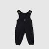 Bickford USA Youth fleece overalls in solid black, laid flat on a light gray background, showing the full front with adjustable shoulder straps with brass snap closures, a chest bib pocket with circular Bickford logo patch, two side cargo pockets, and elasticized ankle cuffs.