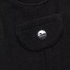 Close-up of the chest bib pocket on the black Youth Overalls showing the circular woven Bickford mountain logo patch centered on the pocket.