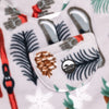 Close-up of the chest bib pocket on the Sugarbush Youth Overalls showing the circular woven Bickford mountain logo patch, with pinecones, pine branches, snowflakes, and skis visible in the surrounding print.