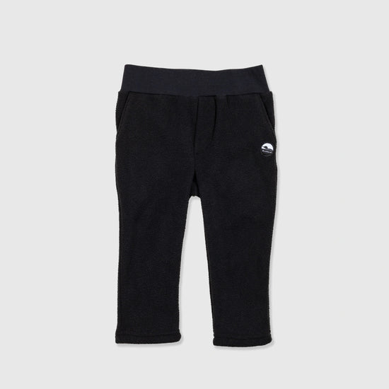 Bickford USA Youth fleece pants in solid black, laid flat on a light gray background, showing the full front with a wide elastic waistband, side hand pockets, and circular Bickford logo patch on the hip.