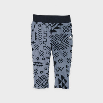 Bickford USA Youth fleece pants in the Boulder colorway, laid flat on a light gray background, featuring an all-over black geometric tribal print on a grey background, with a wide black elastic waistband, side hand pockets, and circular Bickford logo patch on the hip.