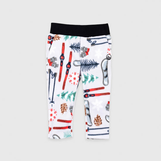Bickford USA Youth fleece pants in the Sugarbush colorway, laid flat on a light gray background, featuring an all-over winter sports print with skis, ski poles, ice skates, mittens, snowflakes, and pine trees on a white background, with a wide black elastic waistband, side hand pockets, and circular Bickford logo patch on the hip.
