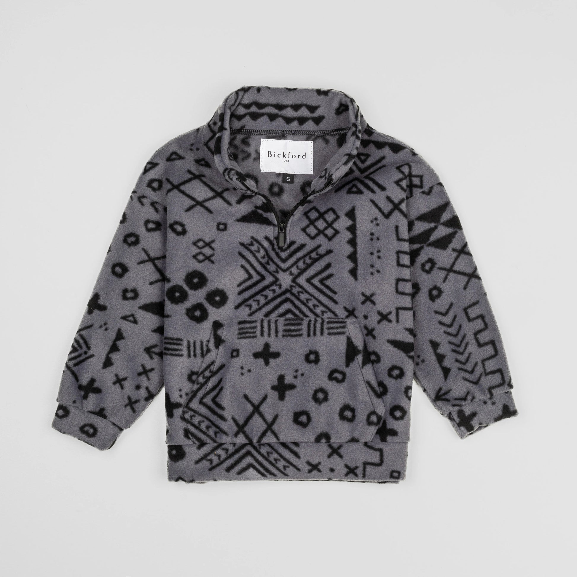 Bickford USA Youth Quarter-Zip fleece pullover in the Boulder colorway, laid flat on a light gray background, featuring an all-over black geometric tribal print on a grey background, with a funnel collar, quarter-zip closure, and front kangaroo pocket.