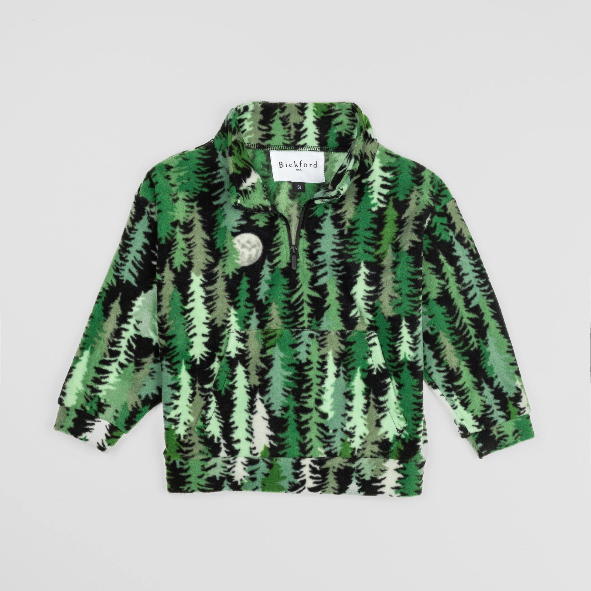 Bickford USA Youth Quarter-Zip fleece pullover in the Eastern Pine colorway, laid flat on a light gray background, featuring an all-over print of layered pine trees in shades of green, black, and cream with a moon motif, funnel collar, quarter-zip closure, and front kangaroo pocket.