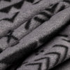 Close-up macro shot of soft fleece fabric in the Boulder colorway — a gray base with a black allover geometric and tribal print — showing the plush texture and depth of the pile.