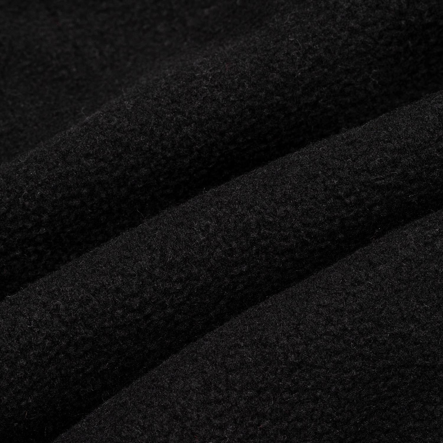 Close-up macro shot of solid black fleece fabric showing the dense, soft pile texture with subtle surface variation.