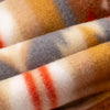 Close-up macro shot of fleece fabric in the Heritage Trail colorway — a Southwestern-inspired pattern in warm tones of tan, rust, orange, gold, cream, and slate blue — showing the soft pile texture and rich color gradations.