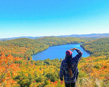 Bickford USA co-founder Vanessa looking out over a lake and autumn forest from a mountain overlook in New England.